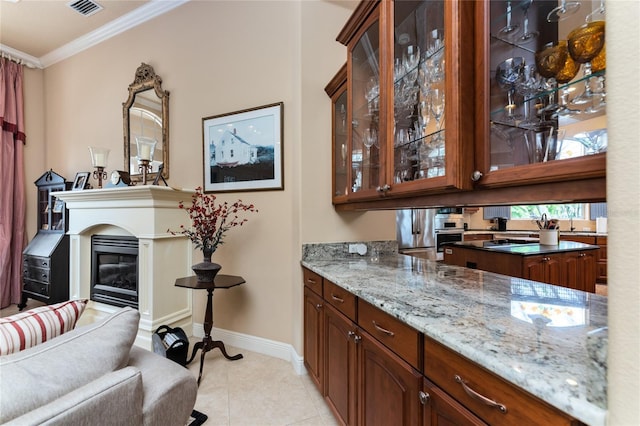 bar featuring light stone countertops, light tile patterned floors, and ornamental molding