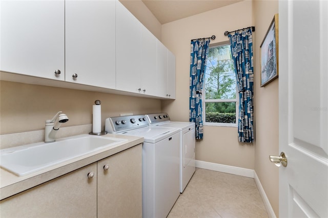 laundry area with independent washer and dryer, cabinets, sink, and light tile patterned flooring