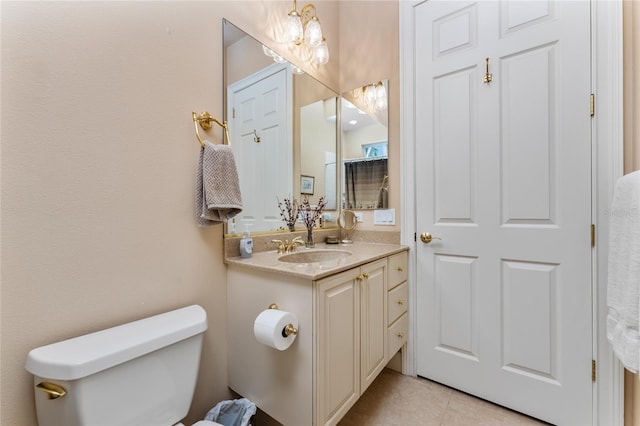 bathroom with tile patterned flooring, vanity, toilet, and a notable chandelier