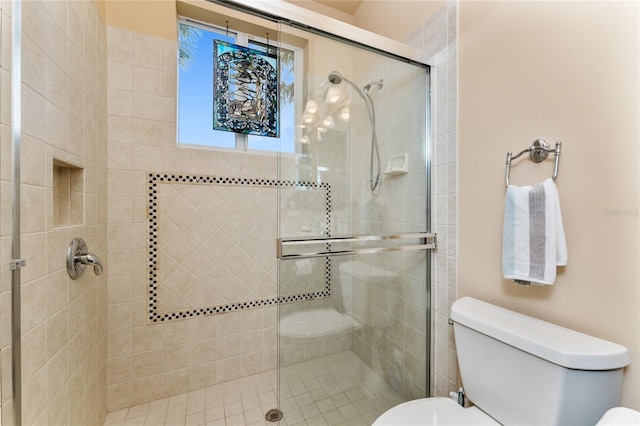 bathroom featuring toilet and an enclosed shower