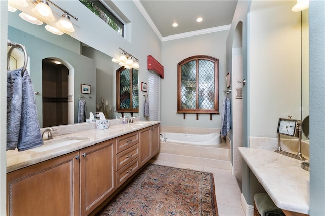 bathroom with vanity, tile patterned floors, tiled tub, and ornamental molding