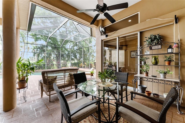 view of patio featuring ceiling fan and glass enclosure