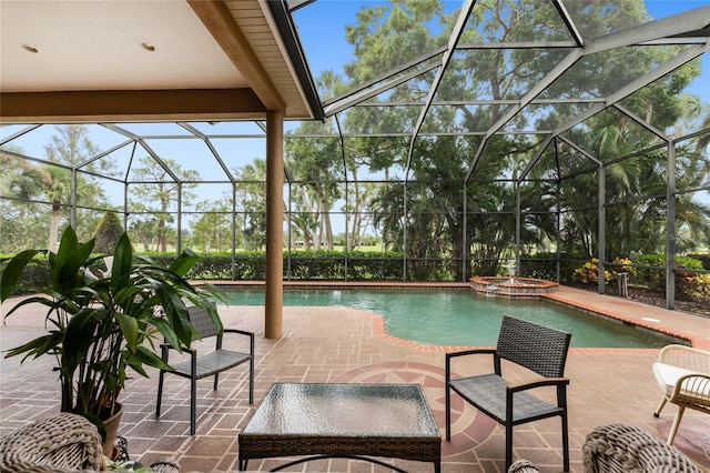 view of pool featuring glass enclosure, a patio, and an in ground hot tub