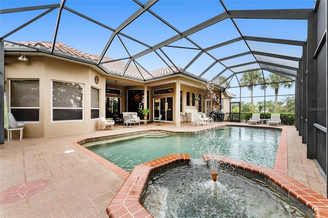 view of pool with glass enclosure, a patio, and an in ground hot tub