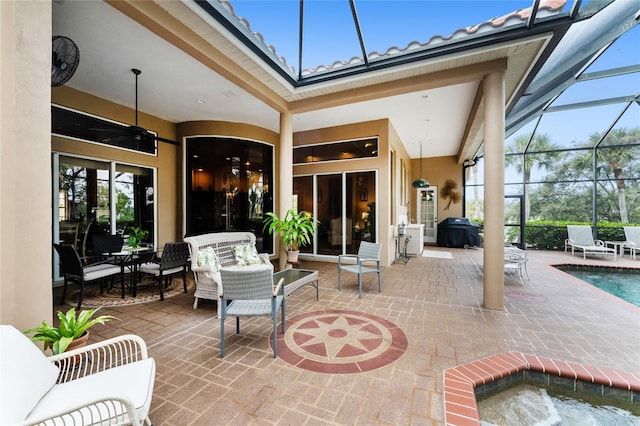 view of patio / terrace featuring glass enclosure, grilling area, and ceiling fan