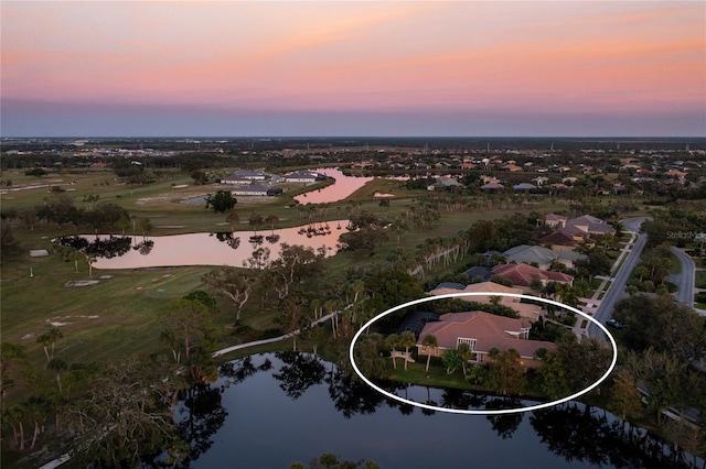 aerial view at dusk featuring a water view