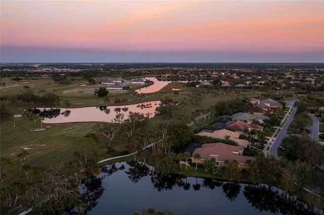 aerial view at dusk featuring a water view