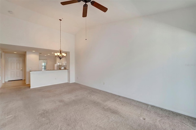 unfurnished living room featuring light colored carpet, high vaulted ceiling, and ceiling fan with notable chandelier