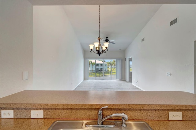 kitchen featuring high vaulted ceiling, sink, hanging light fixtures, and a notable chandelier