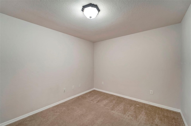 spare room featuring a textured ceiling and carpet flooring