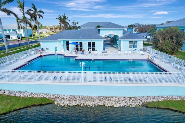 view of swimming pool featuring a water view and a patio