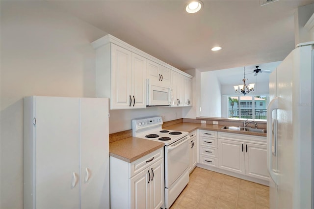 kitchen featuring white cabinetry, sink, hanging light fixtures, and white appliances