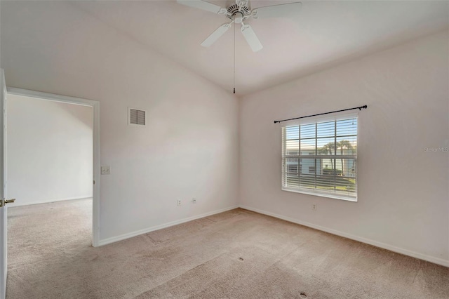 empty room featuring light carpet, vaulted ceiling, and ceiling fan