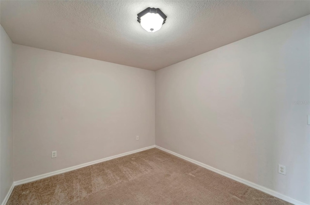 carpeted spare room featuring a textured ceiling