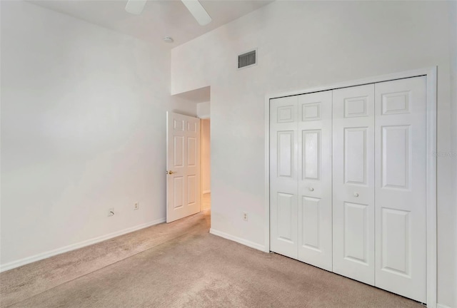 unfurnished bedroom with a closet, ceiling fan, and light colored carpet