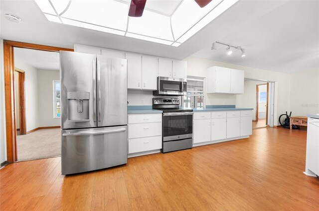 kitchen featuring white cabinetry, stainless steel appliances, and light wood-type flooring