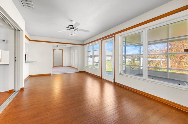 unfurnished room featuring hardwood / wood-style flooring, ceiling fan, and a wealth of natural light