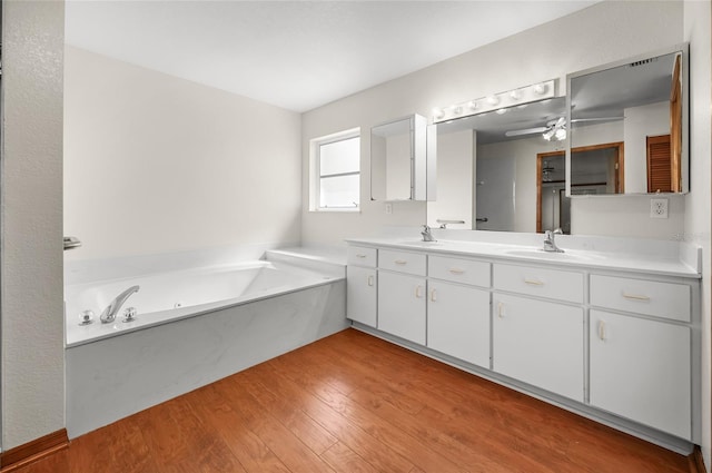 bathroom featuring vanity, hardwood / wood-style floors, a bathtub, and ceiling fan