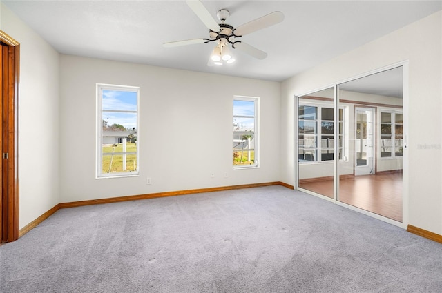 empty room with ceiling fan, a healthy amount of sunlight, and carpet floors