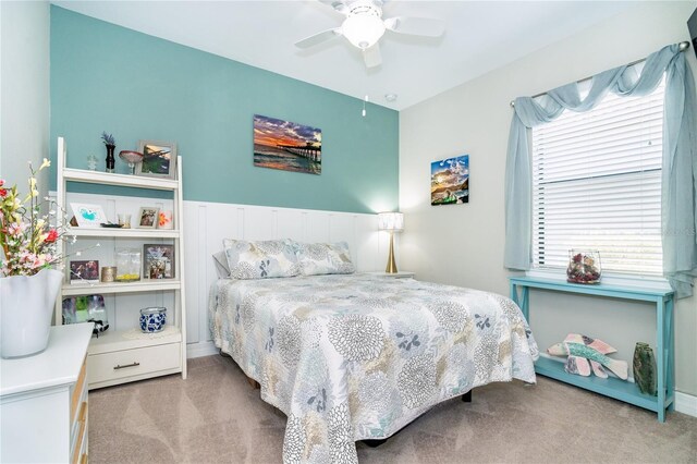 bedroom with ceiling fan, light colored carpet, and multiple windows