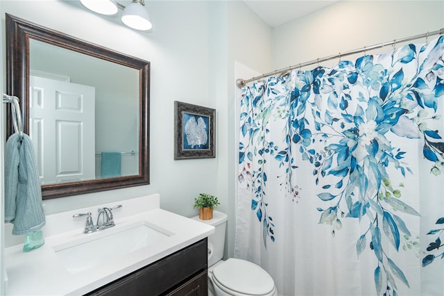 bathroom featuring walk in shower, vanity, and toilet