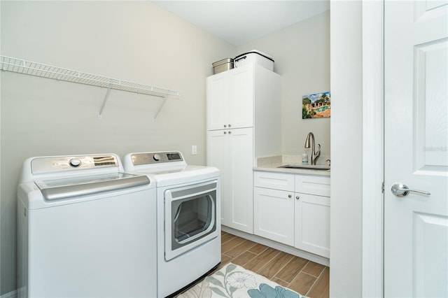 washroom featuring cabinets, sink, and washer and clothes dryer