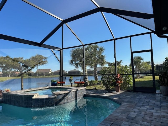 view of pool with a patio area, glass enclosure, and a water view