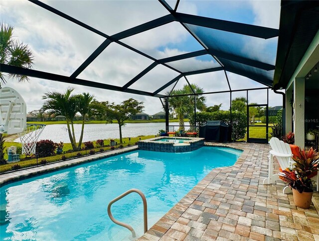 view of pool with a patio, a water view, a lanai, and a pool with connected hot tub