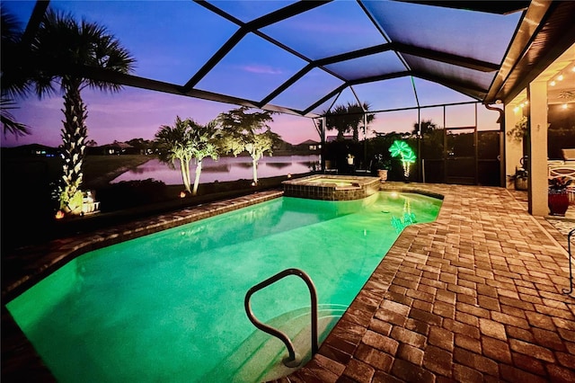 pool at dusk featuring a pool with connected hot tub, a patio, and a lanai