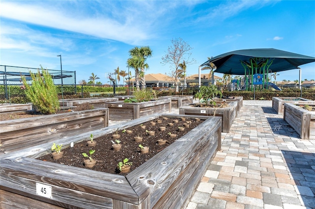 view of home's community featuring fence and a vegetable garden