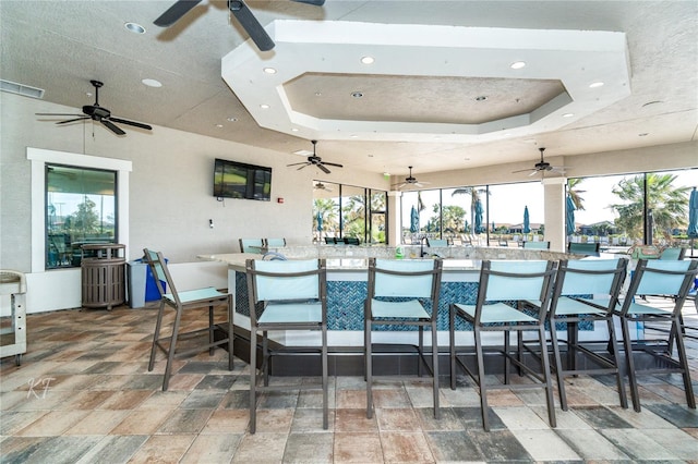 dining room with recessed lighting, a raised ceiling, visible vents, and stone finish floor