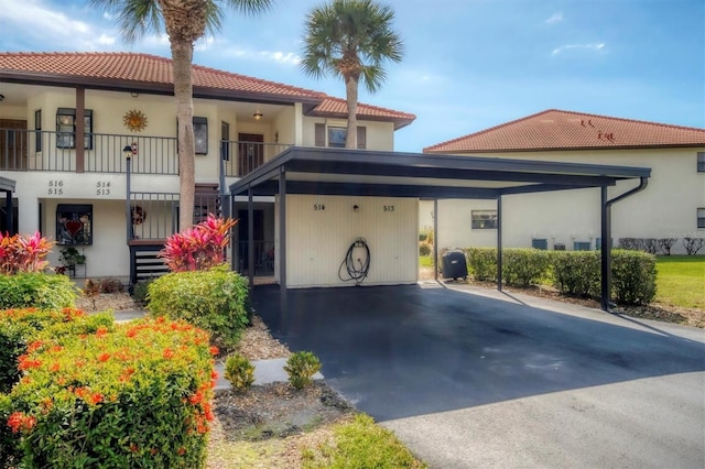 514 Pine Hollow Cir Unit 514, Englewood, FL 34223 - mediterranean / spanish house with a tiled roof, aphalt driveway, a carport, and stucco siding