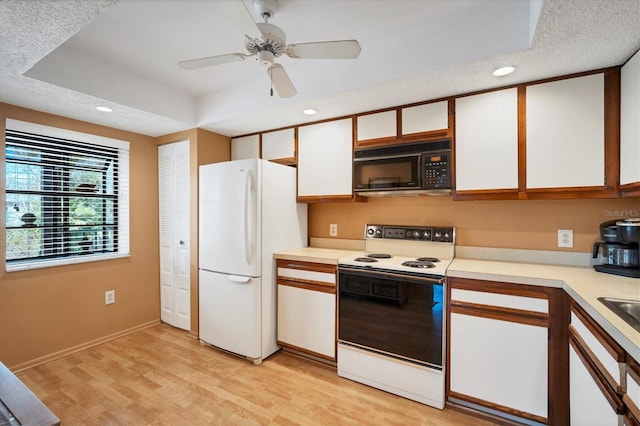 kitchen with white cabinets, white appliances, a textured ceiling, and light hardwood / wood-style flooring