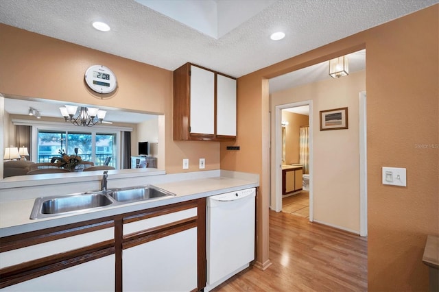 kitchen with white cabinetry, dishwasher, sink, a textured ceiling, and light wood-type flooring