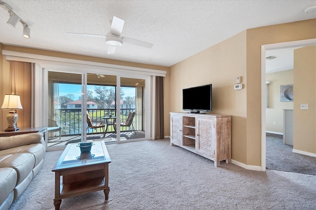 carpeted living room featuring a textured ceiling, track lighting, and ceiling fan