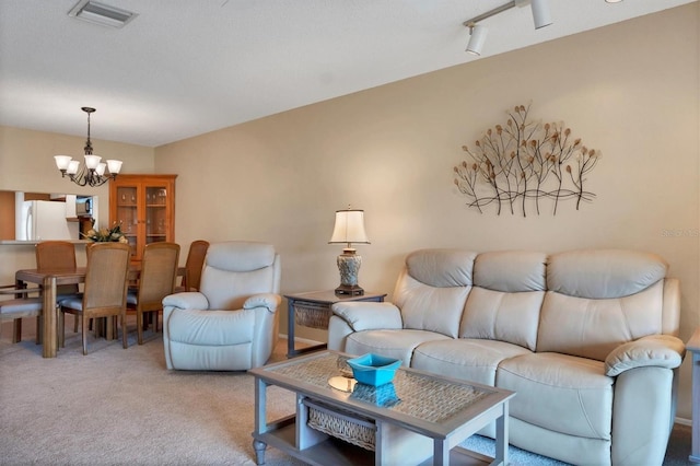 carpeted living room featuring a chandelier