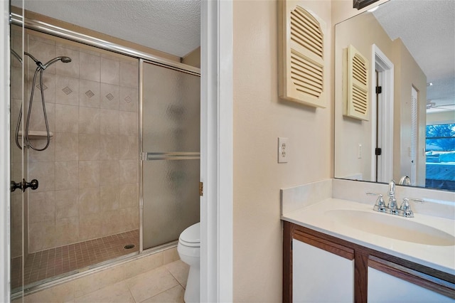 bathroom with tile patterned floors, a textured ceiling, toilet, and a shower with door