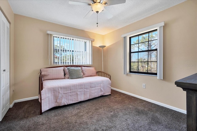 carpeted bedroom featuring a textured ceiling, a closet, and ceiling fan