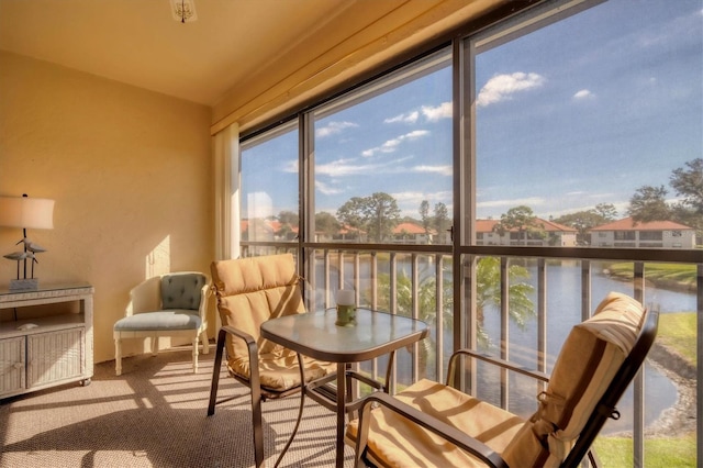 sunroom featuring a water view