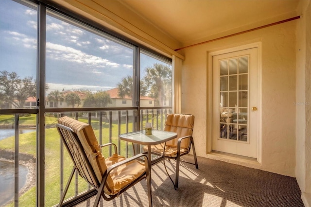 514 Pine Hollow Cir Unit 514, Englewood, FL 34223 - sunroom featuring a water view, a textured wall, and carpet