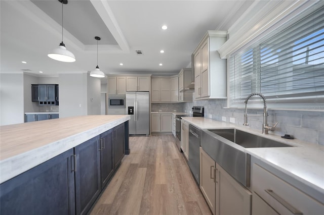 19196 Raymond Ave, Port Charlotte, FL 33954 - kitchen with appliances with stainless steel finishes, backsplash, a sink, light wood-type flooring, and pendant lighting