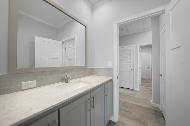 19196 Raymond Ave, Port Charlotte, FL 33954 - bathroom featuring vanity, ornamental molding, decorative backsplash, wood finished floors, and baseboards