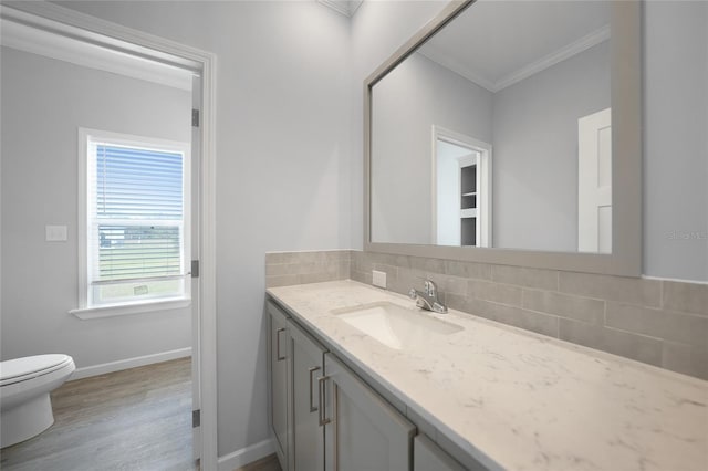 19196 Raymond Ave, Port Charlotte, FL 33954 - bathroom featuring crown molding, vanity, toilet, decorative backsplash, and wood finished floors