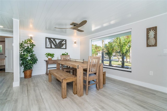 dining room with ceiling fan, wooden ceiling, light hardwood / wood-style flooring, and wooden walls