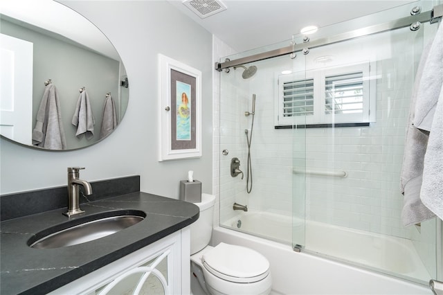 full bathroom featuring vanity, toilet, and shower / bath combination with glass door