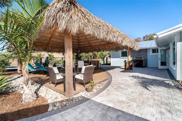 view of patio featuring a gazebo, a wooden deck, and a grill