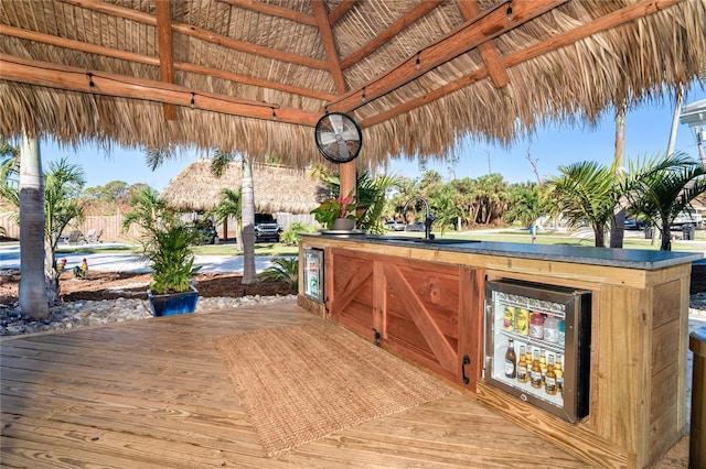 wooden terrace with a gazebo, sink, and beverage cooler