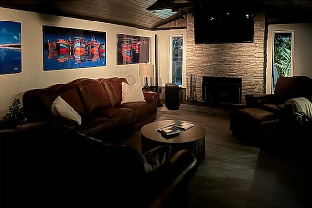 living room featuring hardwood / wood-style flooring, a stone fireplace, wooden ceiling, and vaulted ceiling