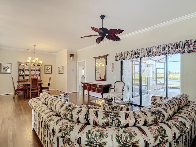 living room with dark wood-type flooring, ornamental molding, and ceiling fan with notable chandelier