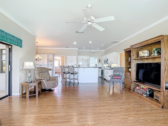 living room featuring crown molding, light wood-type flooring, and ceiling fan